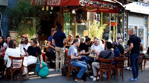 People sit on the terrace of a cafe in Paris
