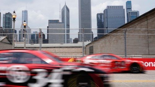 In-motion image of racecars with the Chicago skyline in the background