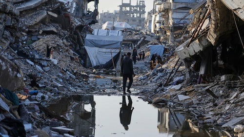 Palestinians walk amid the rubble of destroyed homes and buildings in Jabaliya, northern Gaza Strip