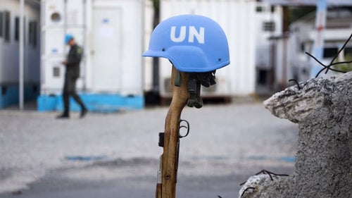 U.N. peacekeeper's blue helmet balanced on a weapon in Port-au-Prince, Haiti