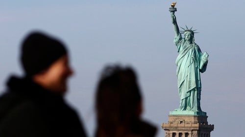 People view the Statue of Liberty in the distance