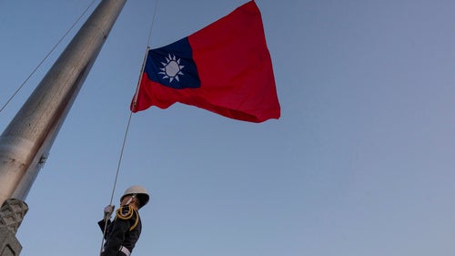 A guard adjusts a Taiwanese flag