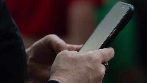 photograph of person's hands holding a smart phone