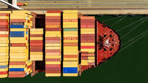 Cargo containers line a ship at the Port of Oakland