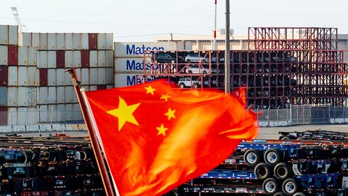Photograph of Chinese flag in front of shipping containers