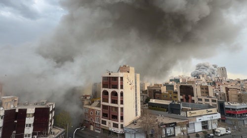 Plumes of smoke from two simultaneous strikes rise over Tehran, Iran