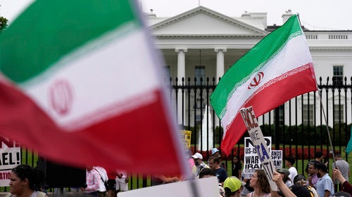 Demonstrators carry signs and wave the Iranian flag as they rally outside the White House,
