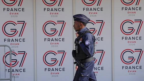 A French police officer walks past G7 logos in Evian-les-Bains
