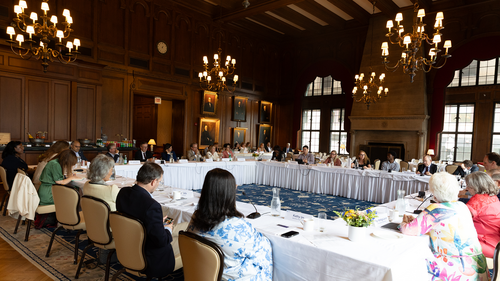 People sit in chairs around a large table