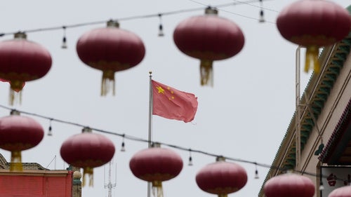 A flag of China is shown between lanterns hanging in Chinatown in San Francisco