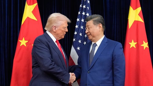 President Donald Trump, left, and Chinese President Xi Jinping, right, shake hands before their meeting at Gimhae International Airport