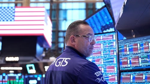 A person stands in front of multiple computer screens