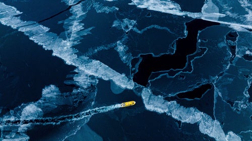 A boat rides though a frozen sea inlet outside of Nuuk, Greenland, on March 6, 2025.