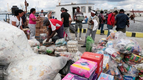 Activists from the vessel Maguro that arrived from Mexico, behind, as part of the "Nuestra America," or Our America convoy, unload humanitarian aid with the help of Cuban port workers in Havana Bay, Cuba, Tuesday, March 24, 2026. 