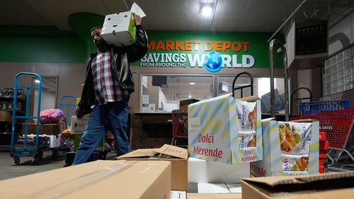 A customer carries grocery products at Market Depot Wholesale Wednesday, March 25, 2026, in Dearborn, Mich. 