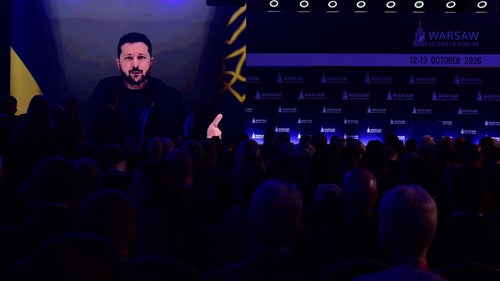 People watch Ukrainian President Volodymyr Zelenskyy on a large screen as he speaks at the Warsaw Security Forum in Warsaw, Poland, Monday, Oct. 12, 2026.