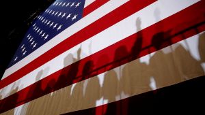 People's shadows projected on a large American flag