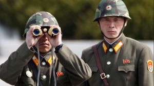 North Korean soldiers look to the South through binoculars while on patrol.