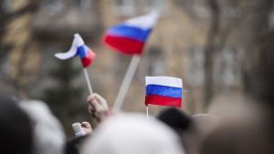 People wave the Russian flag.