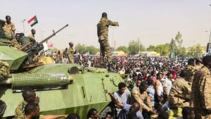 Sudanese soldiers stand guard around armored military vehicles as demonstrators continue their protest against the regime near the army headquarters in Khartoum.