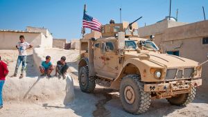 Children gather around a U.S. tactical vehicle in Syria