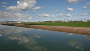 An aqueduct in Blythe, California with reflection of the sky in the water.