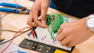 A person attaches wires to a piece of audio equipment