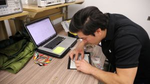 DACA recipient and engineering student works on a circuit board.