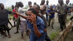 Protesters attack a female police officer accused of shooting a protestor in Burundi