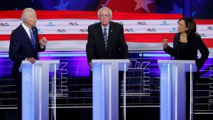 Former Vice President Joe Biden and Senator Kamala Harris debate as Senator Bernie Sanders listens
