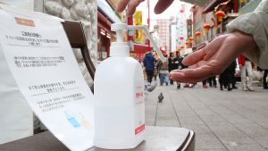 A passer-by disinfects their hands at a festival in Kobe, Hyogo Prefecture, Japan.