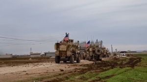 A convoy of U.S military vehicles moves in the village of Khirbet Amo, near Qamishli, Syria