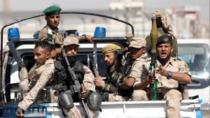 Houthi troops ride on the back of a police patrol truck after participating in a Houthi gathering in Sanaa, Yemen
