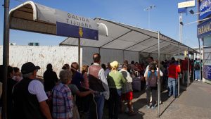 People wait in line at the US-Mexico border. 