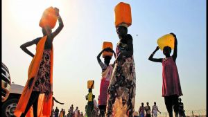 South Sudanese carry water containers on their heads