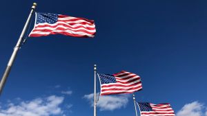 American flags wave in a blue sky