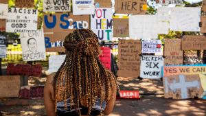 A woman looks at protest signs outside of the White House