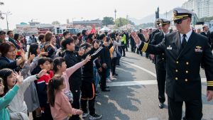 Sailors wave to children while marching in the annual Jinhae Gunhangje military port festival parade in South Korea, April 5, 2019.