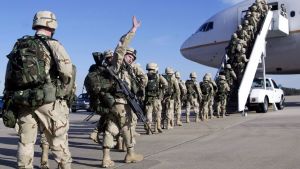 US soldiers board a plane in Iraq, while one waves