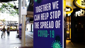 An advertisement on a wall saying "together we can help stop the spread of COVID-19"