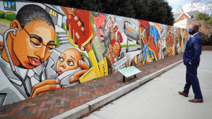 Democratic U.S. Senate candidate Raphael Warnock visits a mural at Elizabeth Porter Historic Monument, the site of an African American hospital, on election day