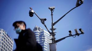A man wearing a face mask walks past surveillance cameras following the coronavirus disease (COVID-19) outbreak, in Shanghai, China