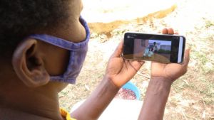 A woman in Kenya watches a SAWBO animation on food storage.