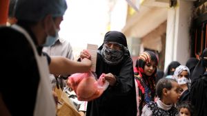 A woman receives food aid in Yemen