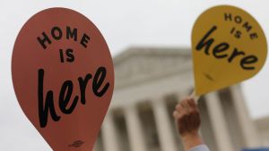 Demonstrators hold signs saying "Home is Here" outside the U.S. Supreme Court
