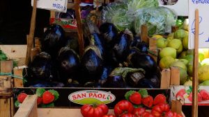 A vegetable stand with prices written in Italian at a market