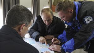 Vladimir Putin talks to Deputy Prime Minister Dmitry Kozak and head of the Federal Road Agency Roman Starovoit as they inspect a transport passage across the Kerch Strait.