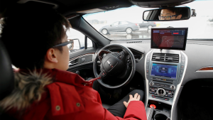 An engineer sits inside an electric car to test drive it