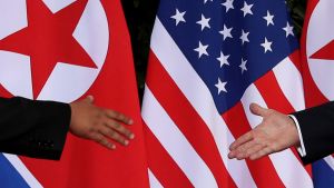 U.S. President Trump and North Korea's Kim shake hands in front of flags