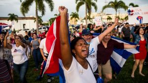 Protestors hold signs and flags in Cuba